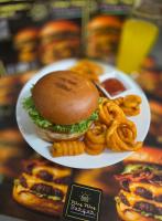 Un plato de comida con una hamburguesa y aros de cebolla. en Hotel Kennedy, en Núremberg