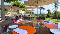 a table with chairs and tables with umbrellas at Relais & Spa Castello di Casiglio in Erba
