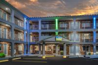 Una vista exterior de un edificio con luz verde. en SureStay Hotel by Best Western Summersville, en Summersville