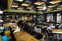 ein Restaurant mit Holztischen und Stühlen und einer Bar in der Unterkunft А17 Plovdiv Apartments - Close to University hospitals, Rowing Channel and Mall Plovdiv in Plowdiw