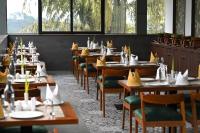 ムンナルにあるBoulevard Premium Luxury Hotelのダイニングルーム(テーブル、ナプキン付きの椅子付)