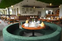 ムンナルにあるBoulevard Premium Luxury Hotelの丸いテーブルと椅子とテーブルのあるレストラン