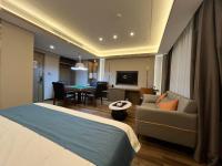 Una habitación de hotel con una cama y una sala de estar. en 万信至格酒店乌鲁木齐机场德港万达店, en Ürümqi