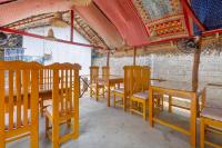 uma fila de mesas e cadeiras de madeira num restaurante em The Baysura Arugambay em Baía de Arugam