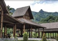 um grande pavilhão de madeira com uma montanha ao fundo em Giri Tengah Resort Borobudur em Ngargoremo