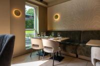 un restaurante con mesa, sillas y ventana en ESSTRA Hotel Erica, en Erica