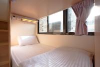 a small bedroom with a bed and a window at Fun Inn Taipei Hostel in Taipei