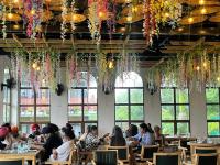 een groep mensen die aan tafels in een restaurant zitten bij Chitralekha Boutique Resort in Rājpur