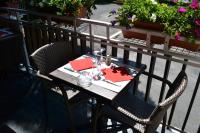 a table and chairs on a balcony with a tableablish at Hôtel la Scala in Pithiviers