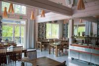 a restaurant with wooden tables and chairs and windows at Aava Hotel in Imatra