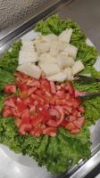 un piatto di cibo con pomodori e formaggio su lattuga di Hotel Guaíba a Guaíba