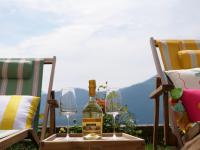 una bottiglia di vino su una scatola accanto a due bicchieri di La Casa Della Seta a Tremezzo