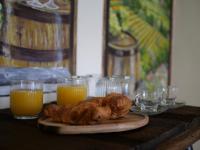 un tavolo con un piatto di croissant e bicchieri di succo d'arancia di La Casa Della Seta a Tremezzo