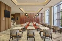 Un restaurante con mesas y sillas en una sala. en Hilton Garden Inn Yingkou Zhanqian, en Yingkou