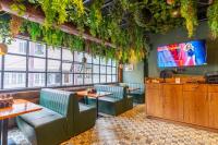 a restaurant with tables and chairs and a flat screen tv at Kava Suites Namchi in Namchi