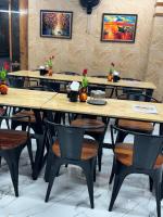 a row of tables and chairs in a restaurant at HOTEL HYDERABAD PULSE in Shamshabad