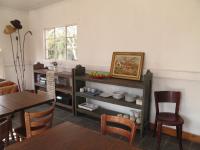 フィックスバーグにあるMarakong at Rustlers Valleyのテーブルと食器が置かれた棚のあるリビングルーム