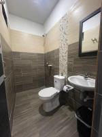 un baño con inodoro y lavabo en Hotel Cayena, en Tame