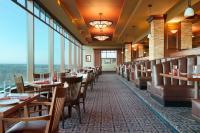 ein Restaurant mit Tischen und Stühlen und großen Fenstern in der Unterkunft Harrah&#39;s Casino &amp; Hotel Council Bluffs in Council Bluffs