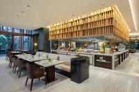 um restaurante com mesas e cadeiras e uma cozinha em Lampung Marriott Resort & Spa em Lampung