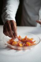 una persona sosteniendo un pedazo de comida en un plato en Hotel Hans, en Copenhague