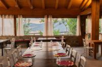 una sala da pranzo con tavoli e sedie e una grande finestra di MonteSoprano Agriturismo - Resort - Spa - Gym -Camping - Suite a Capizzi