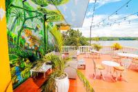 un patio con mesas y sillas y un mural en Hotel Villa del Lago, en Flores