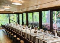 a long table with chairs in a room with windows at Ethno Complex Ukrayinske Selo in Buzovaya
