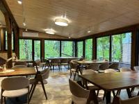 a dining room with tables and chairs and windows at Ethno Complex Ukrayinske Selo in Buzovaya