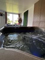 Habitación con bañera grande llena de agua. en Casa Mari, en Cârţişoara