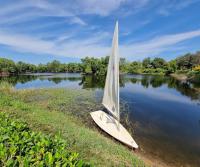 Un pequeño velero sentado en la orilla de un río en Baankao Resort Rayong, en Ban Chamrung