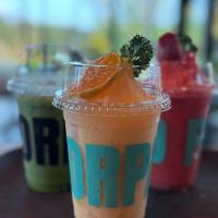 Una bebida con una rodaja de naranja en una taza sobre una mesa. en Baankao Resort Rayong, en Ban Chamrung