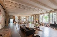 a large living room with a couch and a tv at Design Loft with Private Parking by Rent All Como in Como