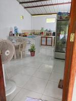 Una sala de estar con una mesa y una cocina. en Hostal La Esmeralda, en El Valle