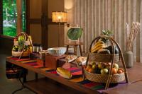 Brij Sone Bagh, Bandhavgarh - A Luxury Jungle Retreat في Tāla: طاولة عليها سلال فواكه وخبز