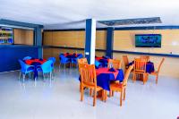 een eetkamer met tafels en stoelen en een tv bij KER HOTEL Dodoma in Dodoma