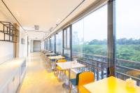 City Comfort Inn Hainan Haikou Wanghai International Plaza Qilou Old Street Branch في هايكو: وجود كافتريا بها طاولات وكراسي ونوافذ كبيرة