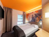 Un dormitorio con una cama grande y una ventana. en B&amp;B HOTEL Hagen, en Hagen