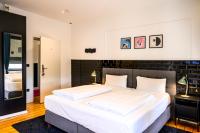 Un dormitorio con una cama grande con sábanas blancas. en Nikii Boutique Hotel, en Leverkusen