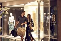 a man and a woman walking in front of a store window at Four Seasons Hotel in Limassol