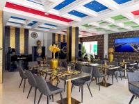 una sala da pranzo con tavoli e sedie e una TV a schermo piatto di HH Riz Resort - Adults Only a Maspalomas