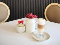 - une tasse de café et des fleurs sur une table dans l'établissement Hotel Santosi, à San Luis Potosí