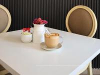 - une tasse de café assise sur une table avec des fleurs dans l'établissement Hotel Santosi, à San Luis Potosí