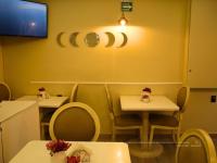 un restaurant avec deux tables et chaises et une télévision dans l'établissement Hotel Santosi, à San Luis Potosí