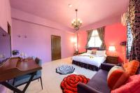 a bedroom with pink walls and a bed and a desk at Hualien Macaron B&amp;B in Ji&#39;an