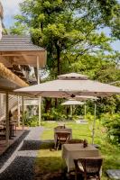 a patio with two tables and an umbrella at Wan'an Tinglan Wild Luxury Resort Hotel in Jinghong
