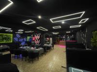 Un comedor con mesas, sillas y luces. en Mehran, en Andizhan