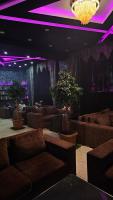 a lobby with couches and potted plants and a purple lighting at City Hotel Baku in Baku