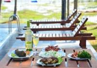 uma mesa com dois pratos de comida e uma garrafa de vinho em Genge Lake Resort - Kalpitiya em Pallivasalturai