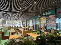 Un restaurante con mesas y gente sentada en las mesas. en Poly Pivot International Aparthotel Guangzhou East Railway Branch - Free Shuttle Bus to Canton Fair Complex During Canton Fair Period, en Guangzhou